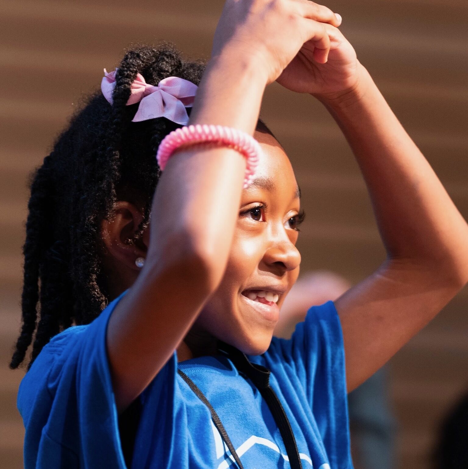 Young girl dancing and smiling during Harambee